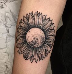 a sunflower tattoo on the arm with a black and white image of a flower