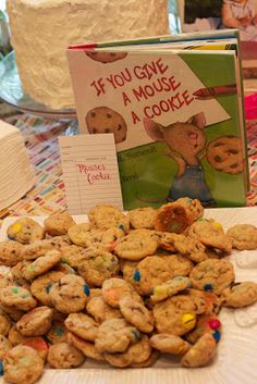 a table topped with cookies next to a cake and a sign that says if you give a mouse a cookie