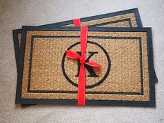 three place mats with red ribbon tied around them on the floor next to each other