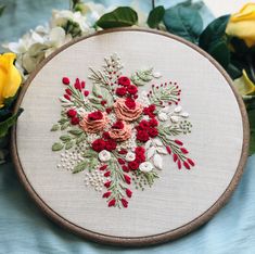 a close up of a embroidery on a table with flowers