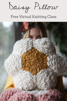 a woman covering her face with a crochet pillow