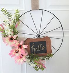 a door hanger with flowers and a chalkboard sign hanging on it's side