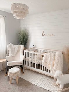 a baby's room with a crib, rocking chair and sheep rugs