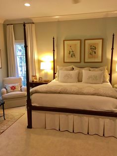 a bedroom with four poster bed, two chairs and pictures on the wall above it