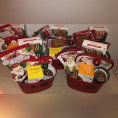 several red baskets filled with different types of christmas treats and candies on top of a table