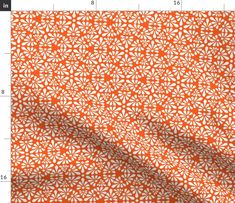 an orange and white fabric with small flowers on the side, as well as a ruler