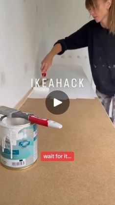 a woman is painting a wall with white paint