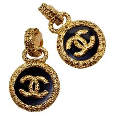 Introducing the exquisite Chanel 1993 Gold Tone Black CC Medallion Florentine Earrings, a stunning pair that exudes timeless elegance and sophistication. Crafted with meticulous attention to detail, these earrings are sure to elevate any ensemble with their unique design and impeccable craftsmanship. The earrings feature textured gold-plated discs adorned with black enamel charms, each embellished with a striking gold-plated CC logo at its center. This iconic Chanel motif adds a touch of luxury and glamour to the design, making these earrings a true statement piece. With their clip-on style, these earrings are both comfortable to wear and easy to style. The textured gold finish adds a unique and eye-catching touch that sets them apart from the rest of your collection, ensuring you stand ou Luxury Chic Black Enamel Jewelry, Luxury Polished Clip-on Earrings For Formal Occasions, Luxury Gold Engraved Earrings, Luxury Engraved Gold Earrings, Luxury Polished Finish Clip-on Earrings For Evening, Luxury Polished Clip-on Earrings For Evening, Luxury Polished Clip-on Earrings For Anniversary, Luxury Clip-on Earrings For Formal Occasions, Luxury Engraved Earrings For Anniversary