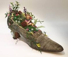 an old shoe with flowers and plants in it