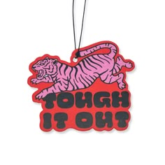 a red ornament that says tough to hit with a pink tiger on it