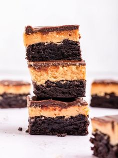 a stack of chocolate brownies with peanut butter frosting on top and one cut in half