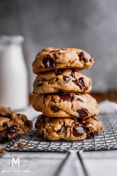 chocolate chip cookies stacked on top of each other with a glass of milk in the background