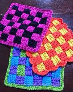 three crocheted coasters sitting on top of a wooden table