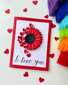 a card that says i love you with hearts on it and a flower in the center