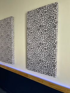 three black and white paintings hanging on the wall