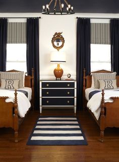 two beds in a room with black and white decor