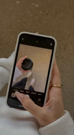 a person holding up a cell phone to take a selfie with their reflection in the screen