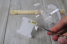 a person is holding scissors next to a piece of plastic