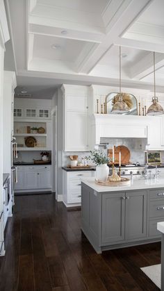 a large kitchen with white cabinets and wood flooring is seen in this image from the doorway