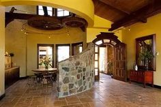 a large room with yellow walls and stone flooring is seen in this image from the entry way