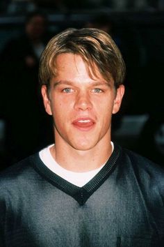 the young man is wearing a black sweater and looking at the camera with an intense look on his face