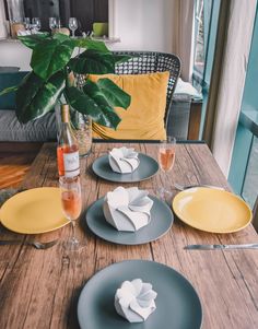 a wooden table topped with plates and glasses