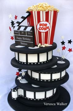 a birthday cake made to look like a film strip and popcorn bucket with stars around it