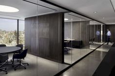 a conference room with glass walls and an open view of the city from it's windows