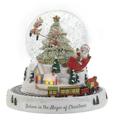 a snow globe with santa claus and reindeers on the roof in front of a christmas tree