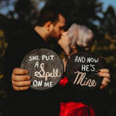 a man and woman kissing while holding signs that say she put a spell on me