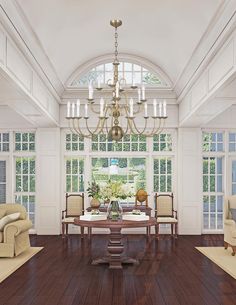 a dining room with wood floors and chandelier