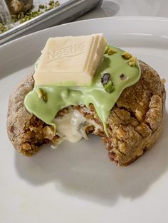 a white plate topped with a pastry covered in green frosting