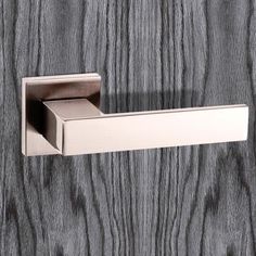 an open door handle on the side of a wooden door with grey woodgrain