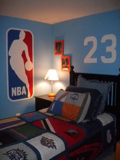 a bed room with a neatly made bed and a basketball themed wall decal on the wall