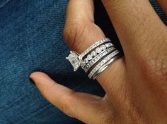 a woman's hand with three rings on her finger and one ring in the middle