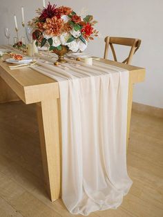 the table is set with candles and flowers on it, along with plates and silverware