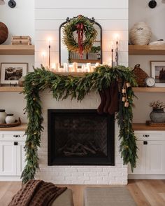 a fireplace decorated with greenery and candles