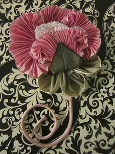 a pink flower sitting on top of a black and white wallpaper covered floor next to a pair of scissors