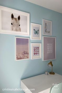 there are pictures on the wall above the desk and below it is a white dresser