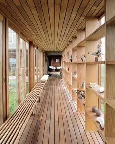 the inside of a wooden building with lots of shelves on each side and windows to the other side