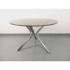 a round glass table with metal legs