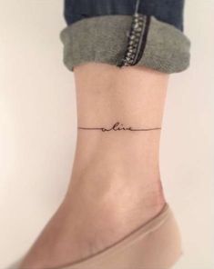 a woman's foot with a small tattoo on the ankle that reads, love