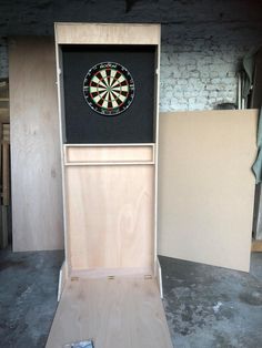 a dart board and darts in a wooden cabinet