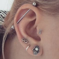 a close up of a person with ear piercings on their ears and behind the ear