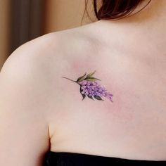 a woman's shoulder with a flower tattoo on it