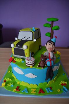 a birthday cake with a man and dog sitting on the ground next to a truck