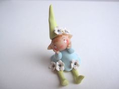 there is a small figurine that has flowers on it's head and legs