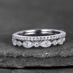 three stone diamond wedding ring set on top of a rock with black and white background