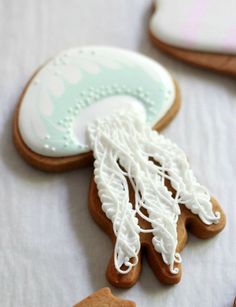 some cookies are laying on a table with white frosting and blue trimmings