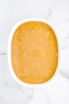 a white bowl filled with soup on top of a marble counter